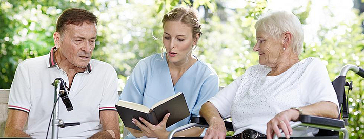 Pflegerin mit Patienten im Park Pflegerin mit Patienten im Park